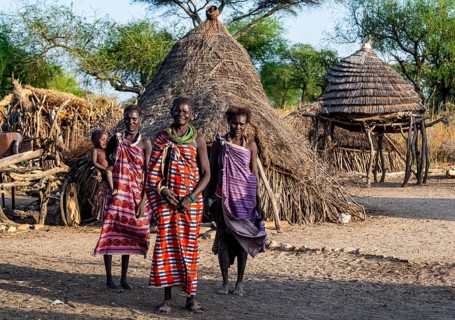 Older women from the Toposa tribe before their traditional hut