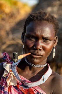 Woman from the Toposa tribe smoking a pipe