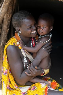 Woman with her baby sitting in a hut