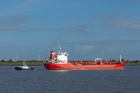Tugboat guiding cargo ship