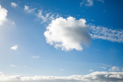 Feather and fleecy clouds adorn the blue sky in strong winds