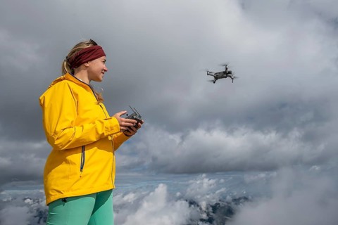 Young woman flying a drone with camera