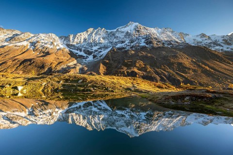 Snow-covered mountains reflected in mountain lake