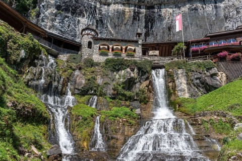 Ensemble of buildings with waterfall in front of the Saint Beatus Caves
