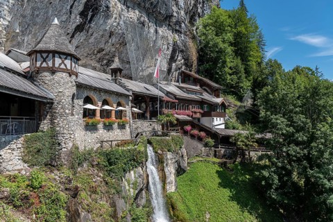 Ensemble of buildings with waterfall in front of the Saint Beatus Caves