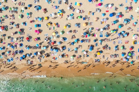 Drone shot of people enjoying the beach and the ocean