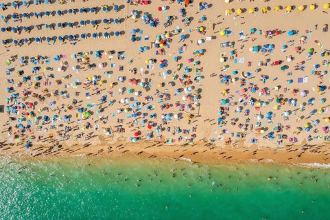 Drone shot of people enjoying the beach and the ocean