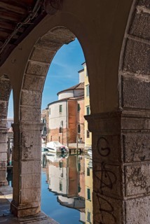 Canal Vena seen throuh arcade of Palazzo Grassi