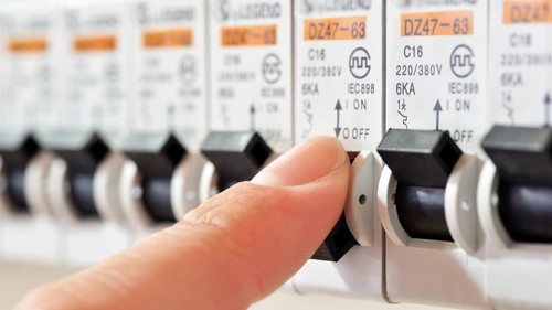 Fuse Box with a finger tripping a circuit breaker