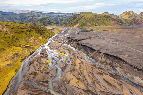 River with fanned out branches through black lava sand