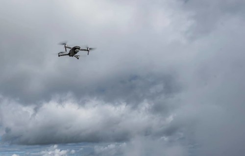 Drone with camera flies in front of clouds