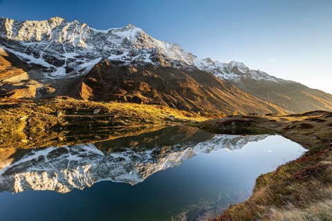 Snow-covered mountains reflected in mountain lake
