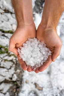 Two hands holding hailstones