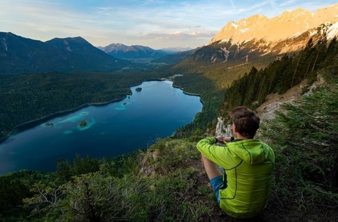 Young man looking over the Eibsee lake at sunset