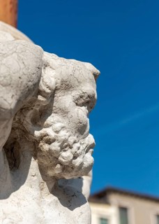 Noseless Telamon statue on city flagpole