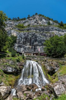 Ensemble of buildings with waterfall in front of the Saint Beatus Caves