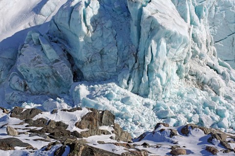 Large ice front of a glacier with crevasses and cracks