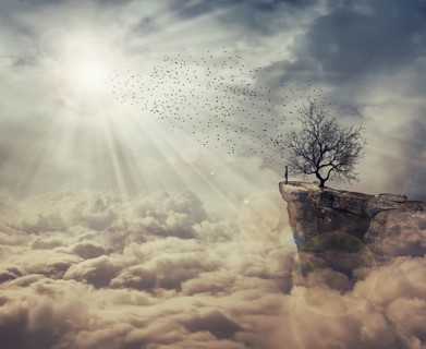Young man standing on the peak of a cliff