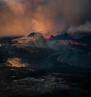 Erupting volcano with lava fountains and lava field