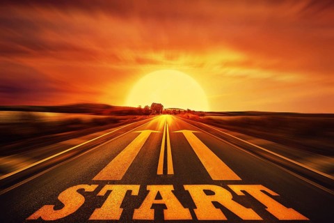 Word Start written on an asphalt road and two arrows as motivation