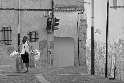 Woman carrying objects through alley in Cuenca