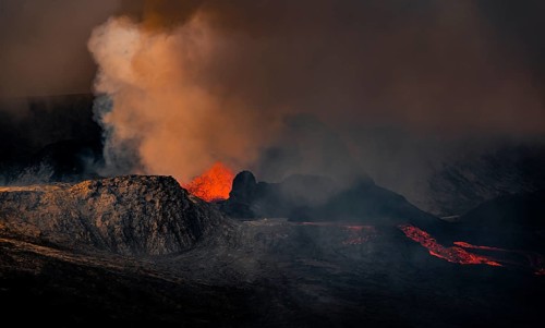 Erupting volcano with lava fountains and lava field