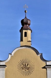 Baroque monogram of the Virgin Mary on the facade of a church