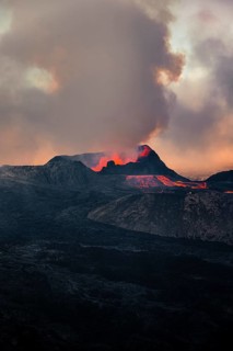 Erupting volcano with lava fountains and lava field