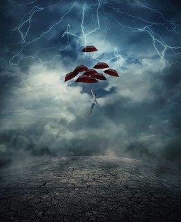 Young man with a lot of umbrellas as an air balloon rise up to the sky full of lightnings