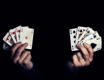 Caucasian male hands holding two royal flush poker combination of heart and spade