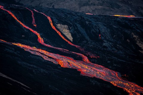Erupting volcano with lava fountains and lava field