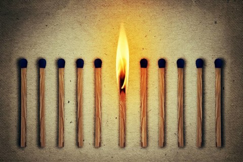 Burning match standing middle a row of whole