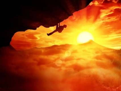 Beautiful sunset background and an alpinist determined to climb a mountain