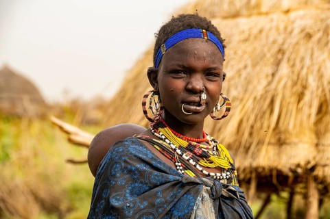 Woman with her child before her hut