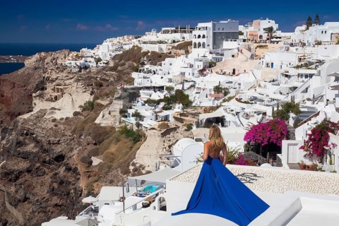 Woman in a blue dress looks over the place Imerovigli