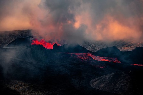 Erupting volcano with lava fountains and lava field