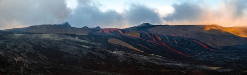 Erupting volcano with lava fountains and lava field