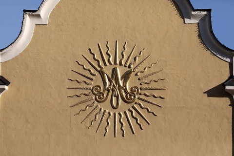 Baroque monogram of the Virgin Mary on the facade of a church