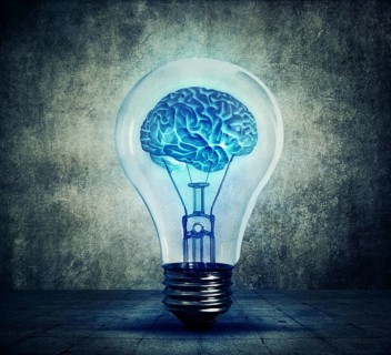 Human brain glowing inside a light bulb