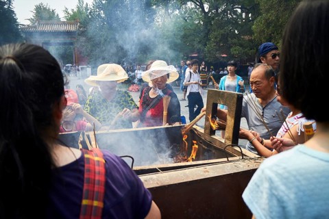 Tourists with incense sticks at the Llama Temple