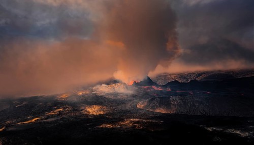 Erupting volcano with lava fountains and lava field