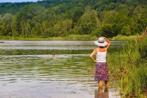 Woman with sun hat and skirt standing in the water