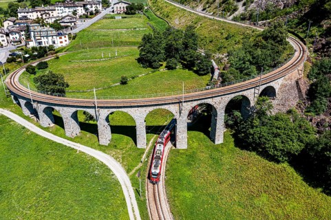 Aerial of a Train crossing the Brusio spiral viaduct