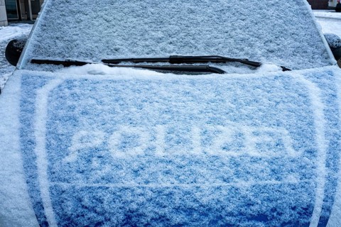 The snowed-in bonnet of a police car