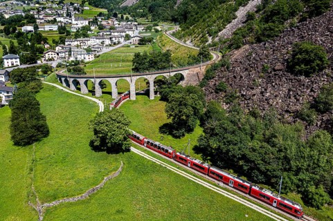 Aerial of a Train crossing the Brusio spiral viaduct
