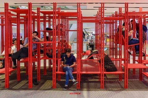 Red iron rack with seating and lounging area for customers to rest