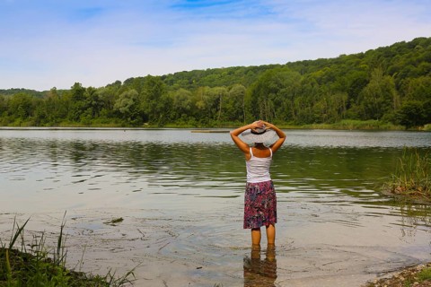 Woman with sun hat and skirt standing in the water
