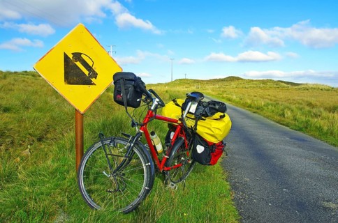 Bicycle in front of road sign warning of steep gradient