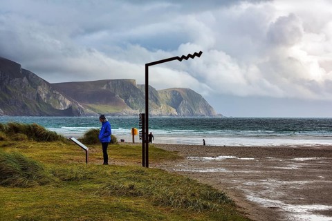 Person reading information board at Keel Strand viewpoint