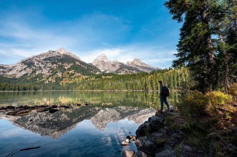 Young man standing by a lake